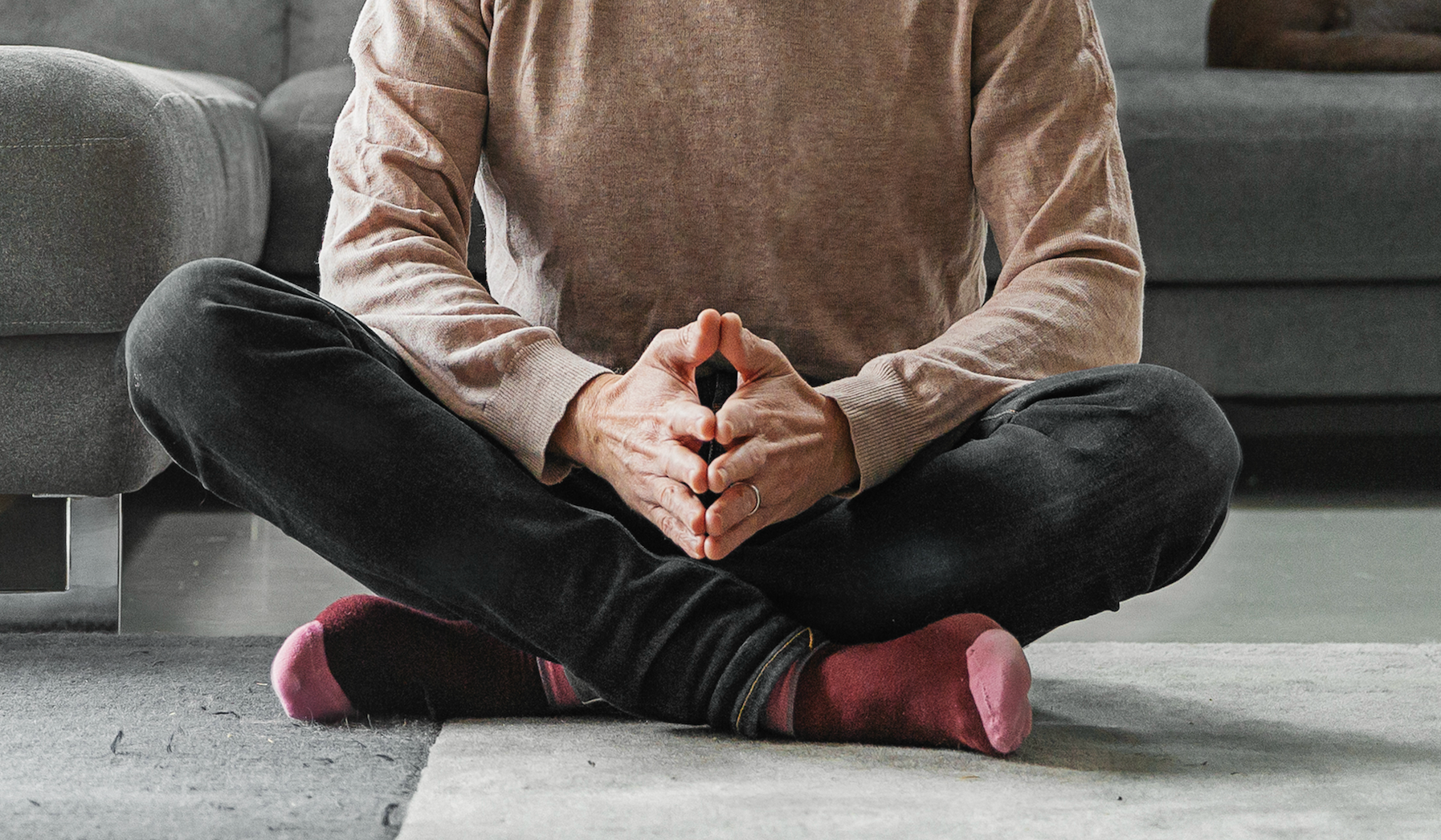 Close up of a man sitting in a cross-legged position.